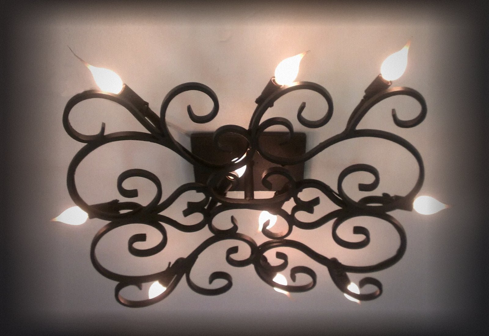 Scrolled iron wall sconce with six candle lights