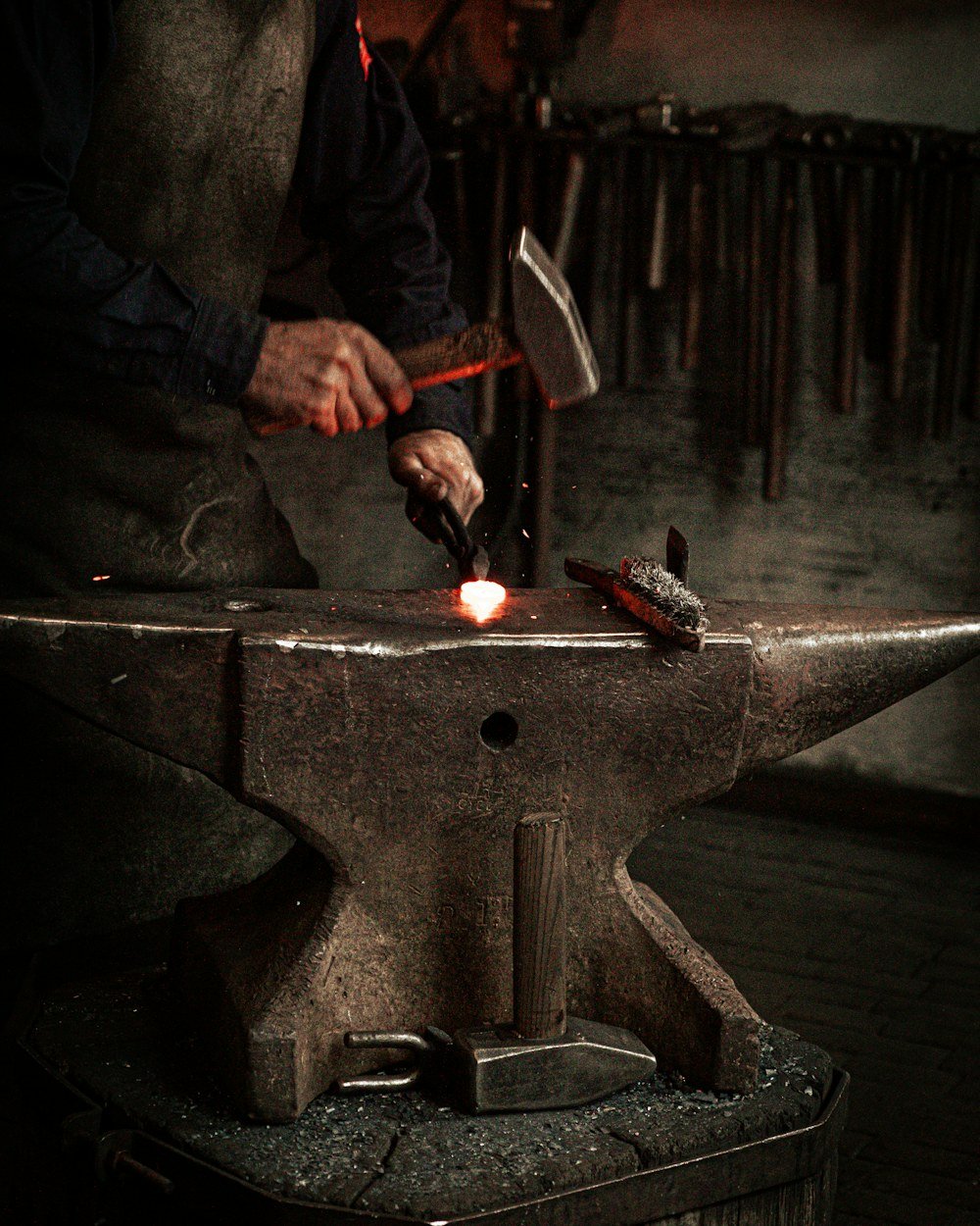 Blacksmith hammering hot iron at the anvil
