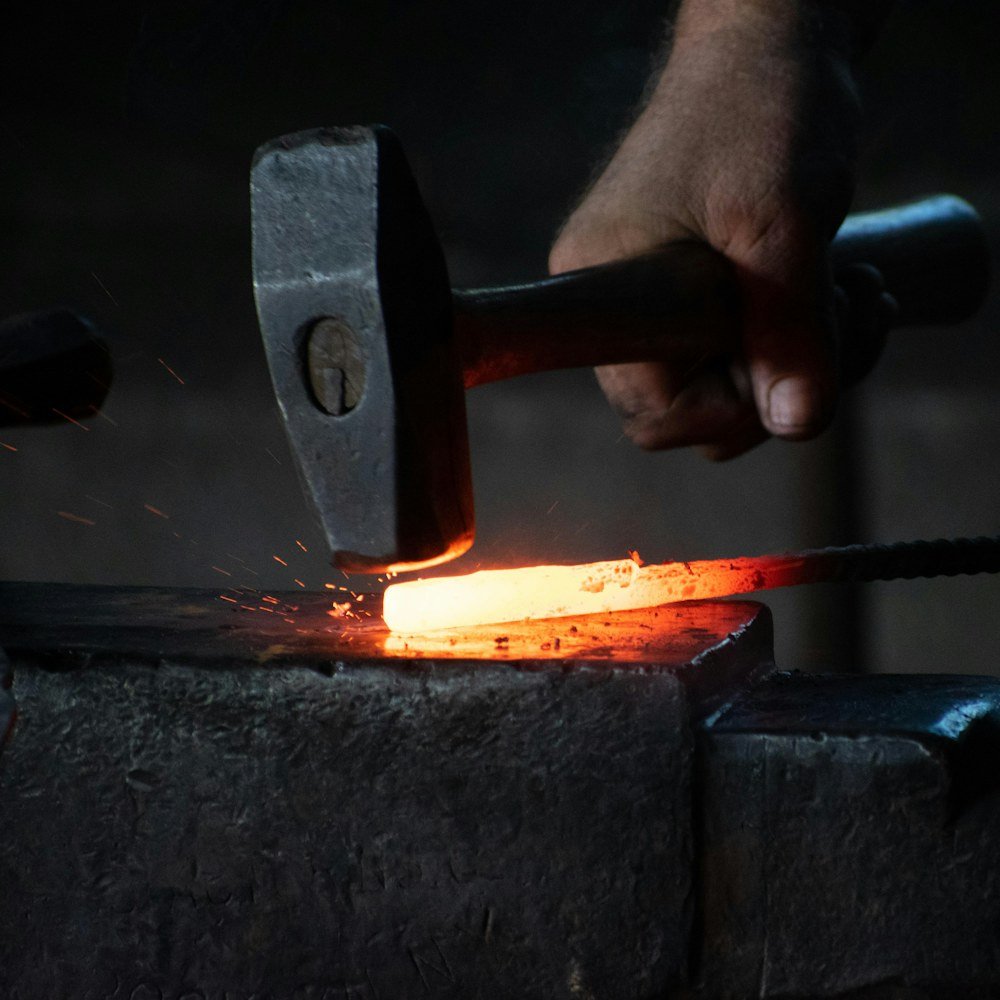Hammer striking a glowing iron bar