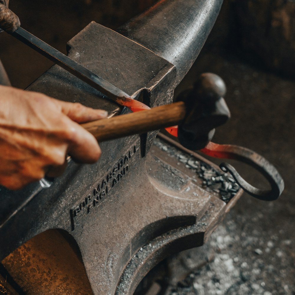 Tongs holding hot iron over the anvil